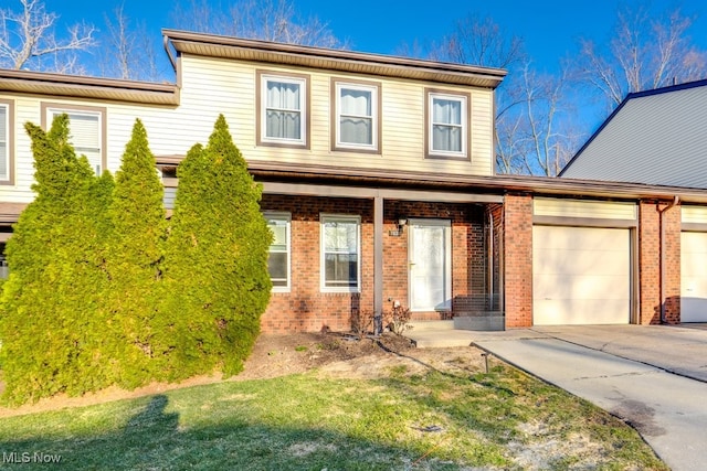 view of front of home featuring an attached garage, brick siding, and driveway