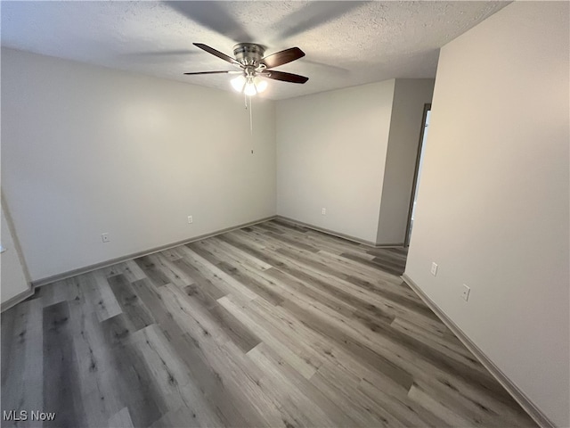 355 Village Pointe Dr Unit 1-A, Akron, OH 44313 - unfurnished room with ceiling fan, light wood-style floors, baseboards, and a textured ceiling