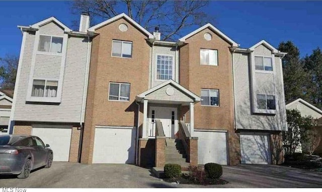 townhome / multi-family property featuring driveway and a garage