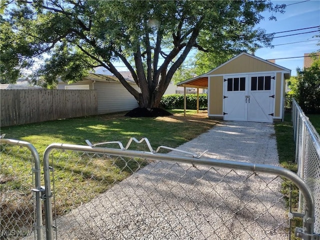 view of yard with an outbuilding, a storage shed, fence private yard, and driveway