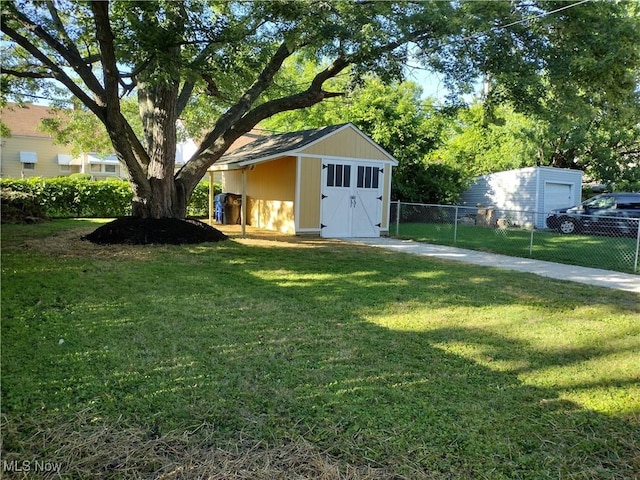 view of yard featuring a storage shed, an outdoor structure, and fence