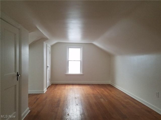 bonus room featuring baseboards, lofted ceiling, and wood finished floors