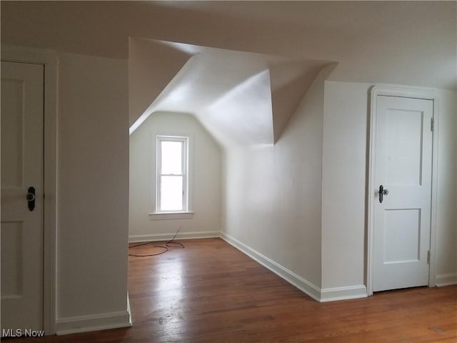 bonus room featuring vaulted ceiling, baseboards, and wood finished floors