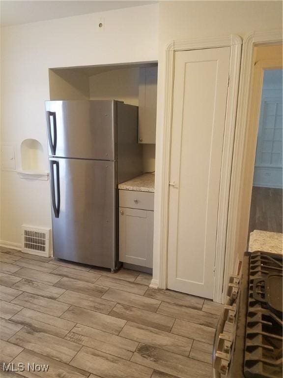 kitchen with visible vents, stainless steel appliances, light countertops, and wood finish floors