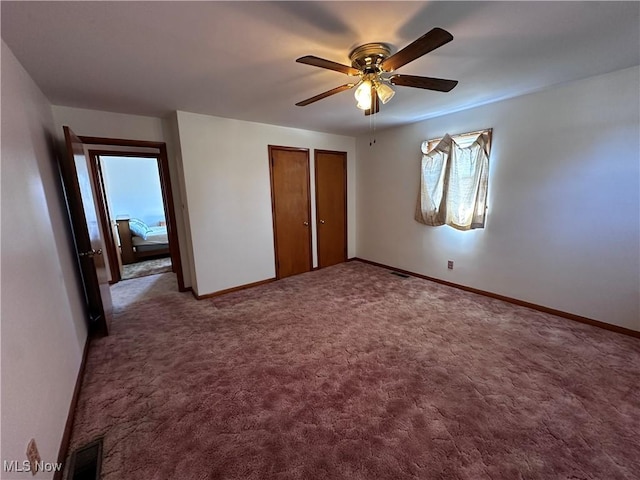 unfurnished bedroom with carpet flooring, visible vents, a ceiling fan, and baseboards