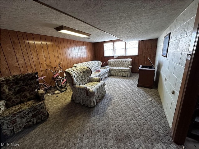 carpeted living room with wooden walls and a textured ceiling