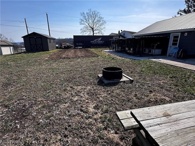 view of yard featuring an outdoor structure, a storage shed, and a patio