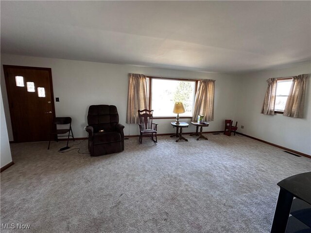 sitting room with visible vents, baseboards, and carpet flooring