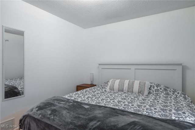 bedroom featuring visible vents and a textured ceiling