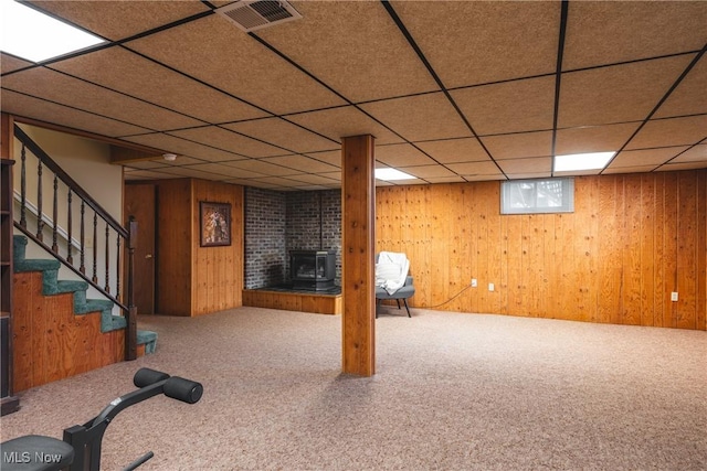 basement featuring stairway, carpet floors, visible vents, and wood walls