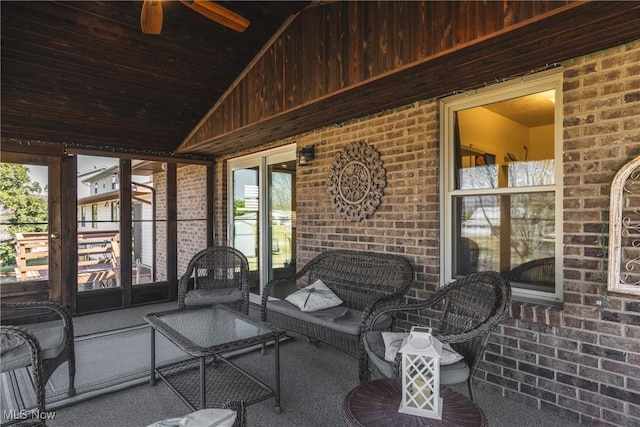 unfurnished sunroom featuring ceiling fan and vaulted ceiling