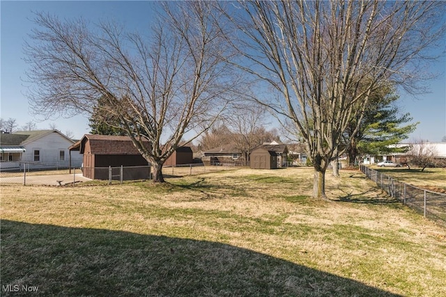 view of yard featuring a fenced backyard, a storage shed, and an outdoor structure