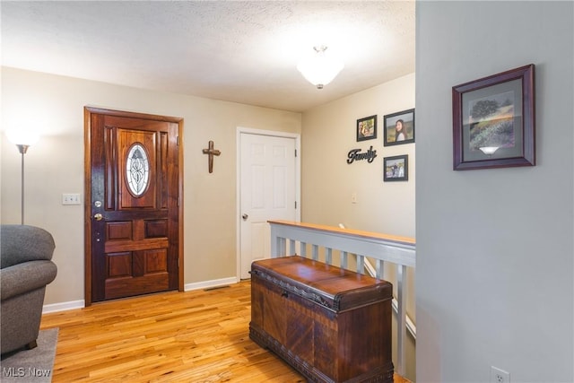 foyer with baseboards and light wood finished floors