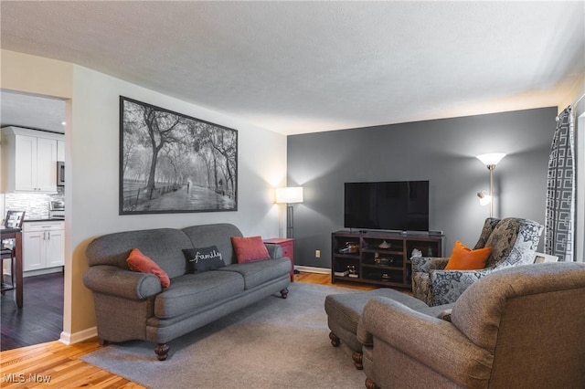 living area featuring baseboards and wood finished floors