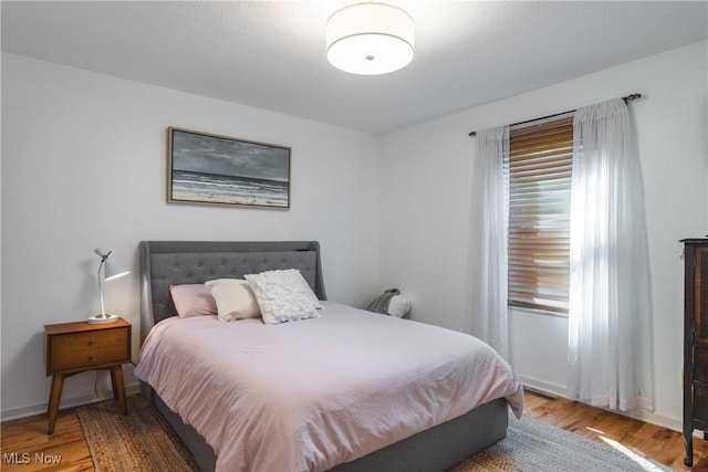 bedroom with baseboards and wood finished floors