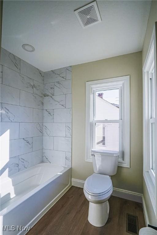 bathroom with visible vents, toilet, baseboards, and wood finished floors