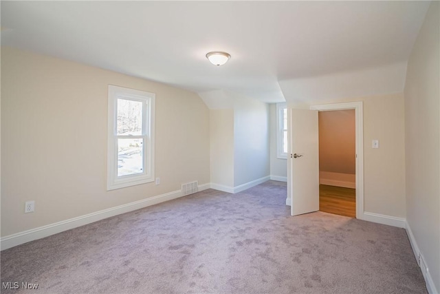 unfurnished room featuring plenty of natural light, baseboards, visible vents, and carpet floors