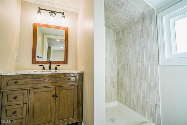 bathroom featuring vanity and tiled shower