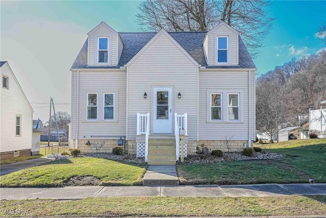 cape cod home with a front yard and a shingled roof