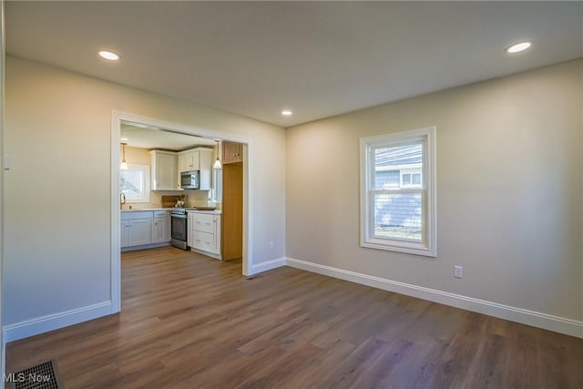 interior space featuring dark wood finished floors, recessed lighting, and baseboards