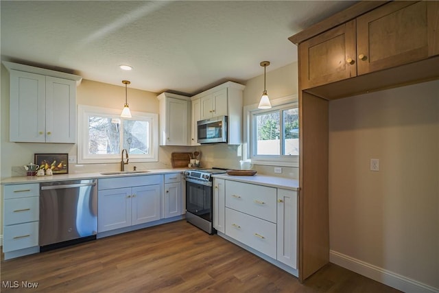 kitchen with plenty of natural light, dark wood-style flooring, stainless steel appliances, and a sink