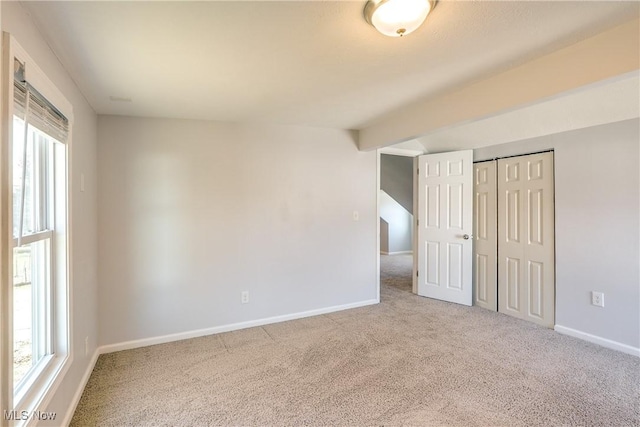 unfurnished room with carpet, baseboards, and a healthy amount of sunlight