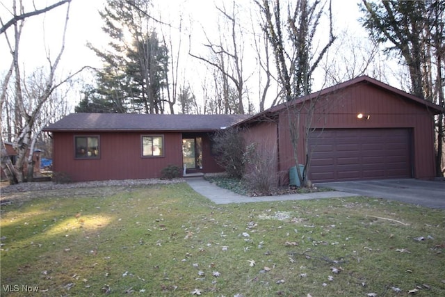 view of front of house with a front yard, an attached garage, and driveway