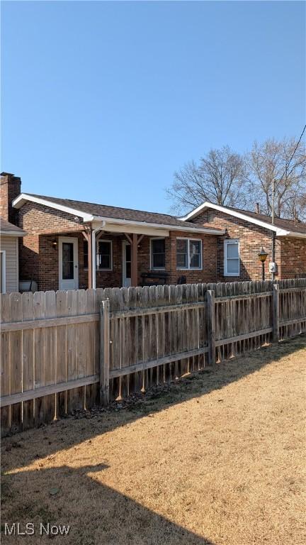 view of front of property featuring brick siding and fence