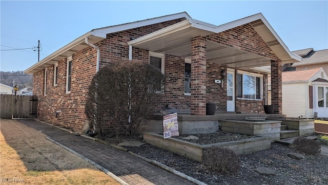 view of front of home with fence and brick siding