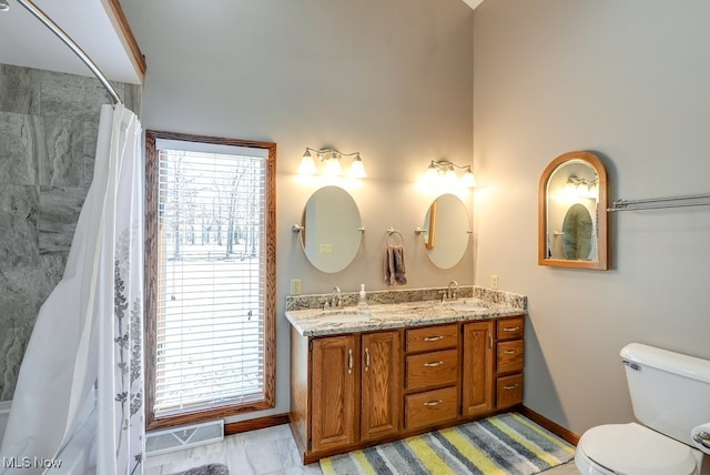 full bathroom with plenty of natural light, toilet, and a sink