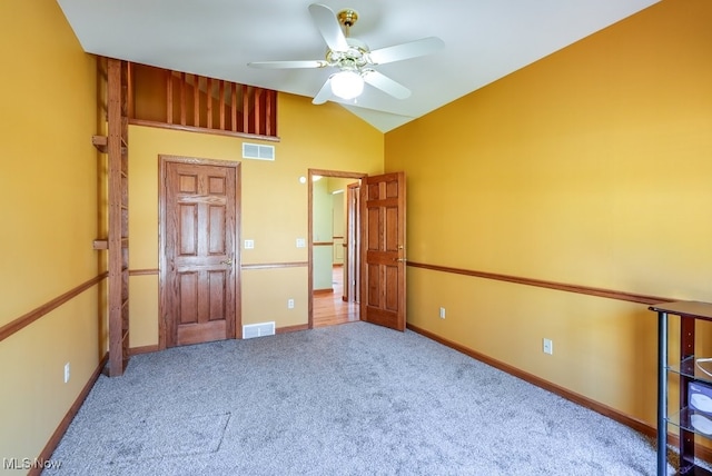 unfurnished bedroom with visible vents, baseboards, carpet, and vaulted ceiling