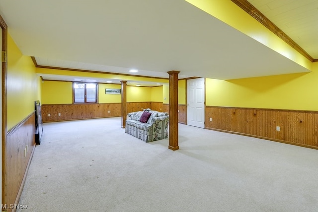 living room featuring ornamental molding, carpet flooring, wood walls, and wainscoting