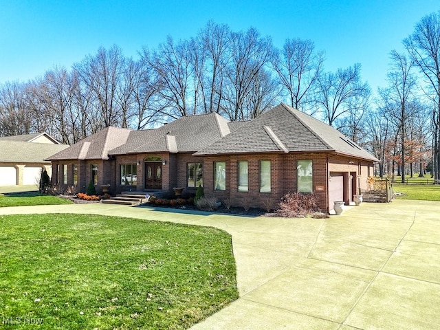 view of front facade with a front yard, a shingled roof, concrete driveway, a garage, and brick siding