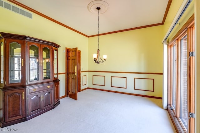 spare room with an inviting chandelier, crown molding, visible vents, and light carpet