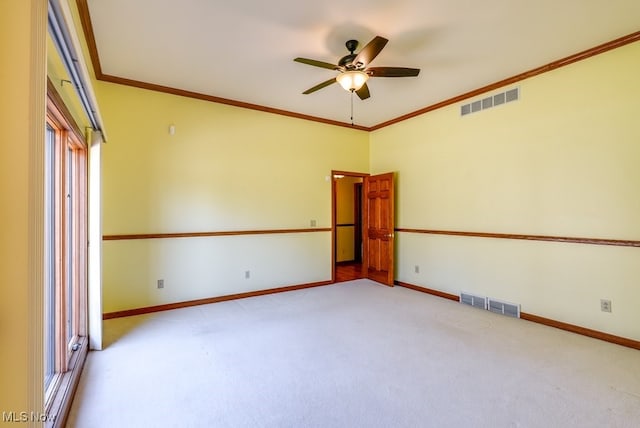 spare room with crown molding, baseboards, and visible vents