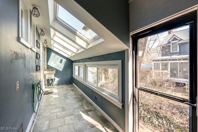 bathroom with baseboards and vaulted ceiling with skylight