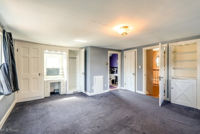 unfurnished bedroom with baseboards and dark colored carpet