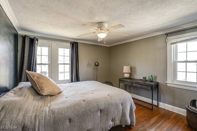 bedroom featuring hardwood / wood-style flooring, a textured ceiling, crown molding, baseboards, and ceiling fan