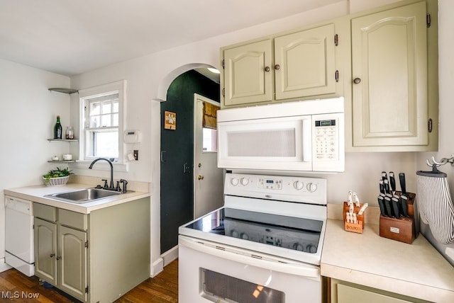 kitchen with white appliances, open shelves, dark wood-style flooring, a sink, and light countertops