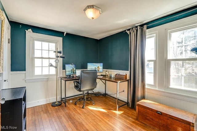 office area with a wainscoted wall and wood-type flooring