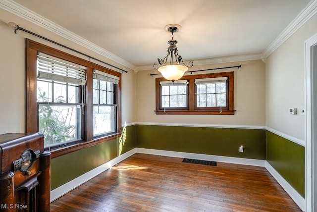 spare room with dark wood-type flooring, visible vents, baseboards, and ornamental molding