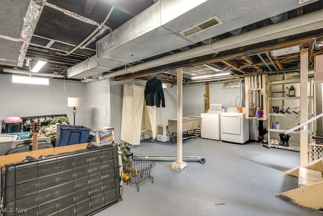 basement featuring washing machine and clothes dryer and visible vents