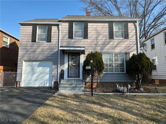 view of front of property featuring aphalt driveway, a garage, and a chimney