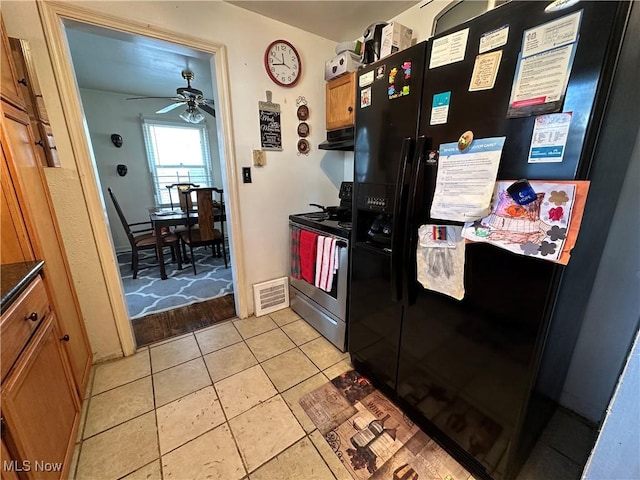 kitchen featuring visible vents, electric stove, under cabinet range hood, dark countertops, and black refrigerator with ice dispenser