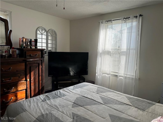 bedroom with multiple windows and a textured ceiling