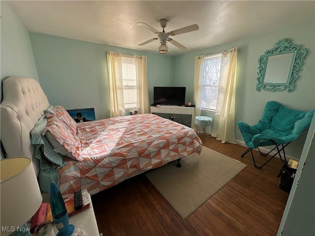 bedroom featuring wood finished floors, baseboards, and ceiling fan