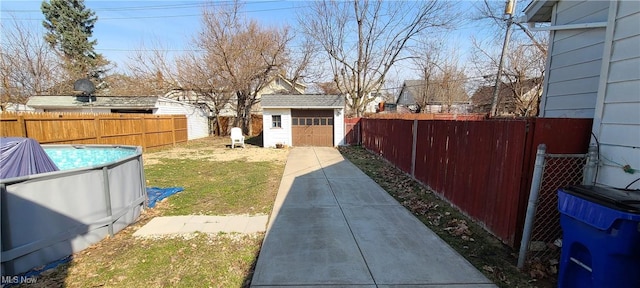 view of yard featuring an outbuilding, a storage unit, a fenced backyard, and a fenced in pool