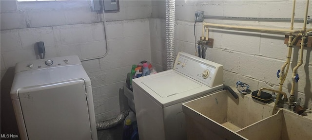 laundry area featuring washing machine and clothes dryer, laundry area, and a sink