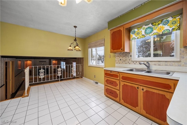 kitchen featuring a sink, tasteful backsplash, and light countertops