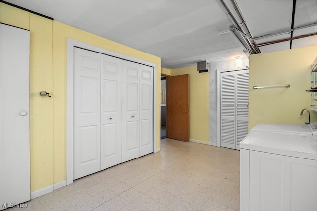 washroom featuring laundry area, light floors, baseboards, and washing machine and clothes dryer